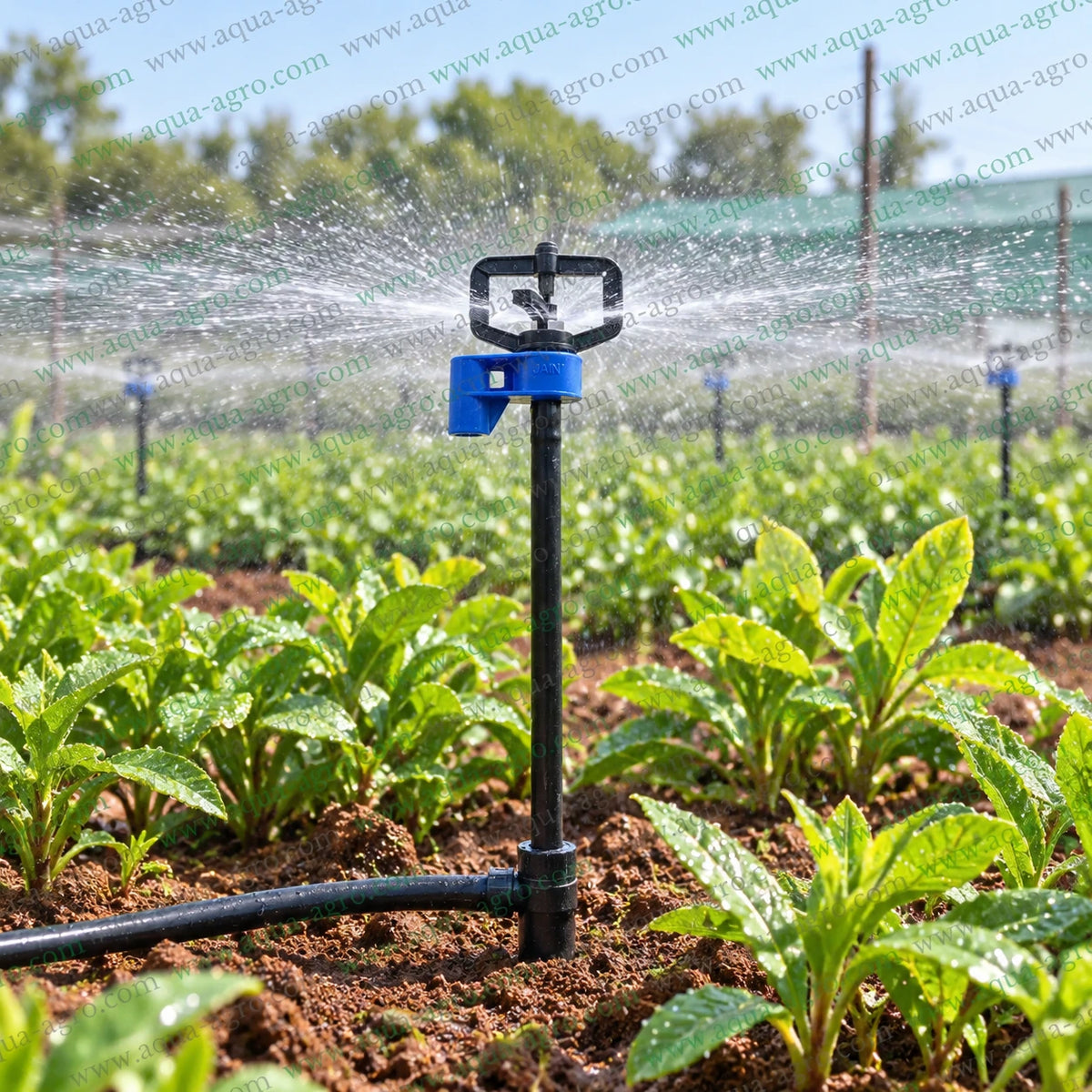 JAIN J-Mini 4mm barbed micro sprinkler operating in agricultural field with 360 degree full circle water spray 9 to 13 feet radius for uniform crop nursery and garden irrigation