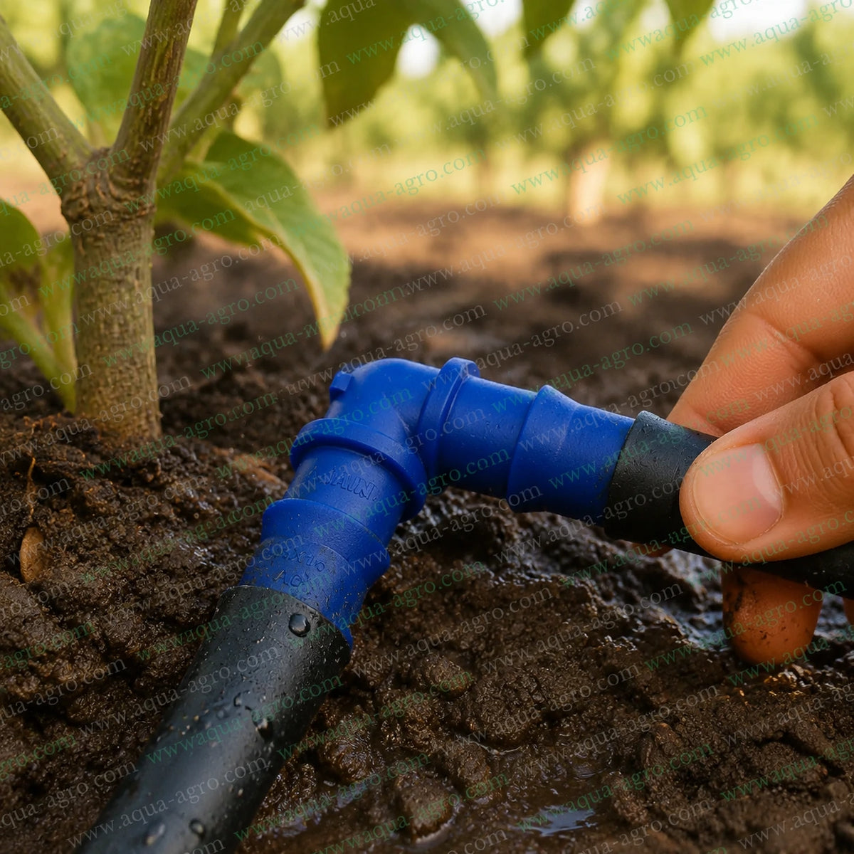 JAIN 16mm blue premium barbed elbow connector installed with black drip irrigation pipes for 90 degree water flow direction change in agricultural irrigation systems