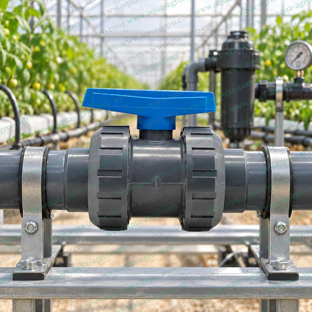 PIMTAS Turkey 1.25 inch 40mm PVC double union ball valve installed on a greenhouse irrigation pipeline with blue handle grey PVC fittings and metal pipe supports for agricultural irrigation drip irrigation and water distribution systems